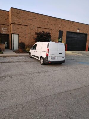 White Van Parked In Front Of A Warehouse